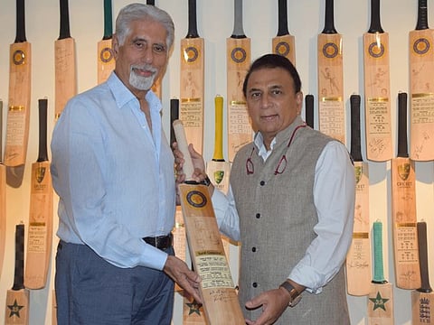 Sunil Gavaskar (right), former Indian captain and batting legend, poses with the bat that he gifted to Shyam Bhatia years back.