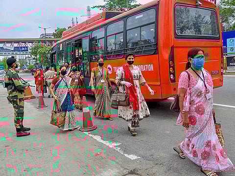 State employees wearing face masks walk to Secretariat to perform their duty, amid COVID-19 lockdown in Guwahati.