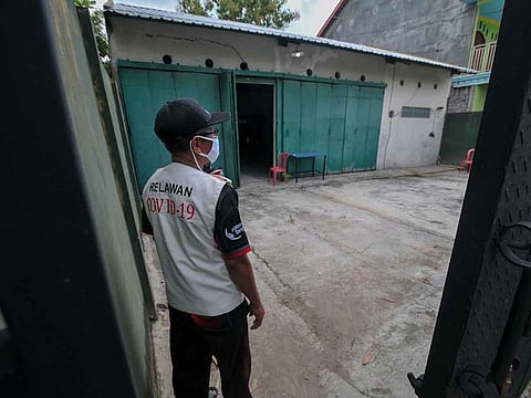 A volunteer looks on at a quarantine facility, a repurposed abandoned house believed by some locals to be haunted and used as a deterrent effect against those breaking social restrictions amid the COVID-19 coronavirus pandemic, at Sepat village in Sragen, Central Java, on April 21, 2020.
