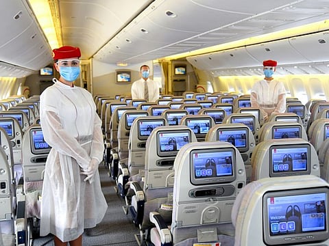 Emirates crew onboard now wear a protective disposable gown over their uniforms and a safety visor in addition to masks and gloves