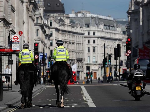 Mounted police officers patrol along a deserted Regent Street in London