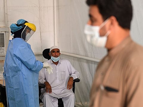 A health worker takes samples from an expatriate worker to check for the novel coronavirus at a testing centre in the Al Quaz area of Dubai.