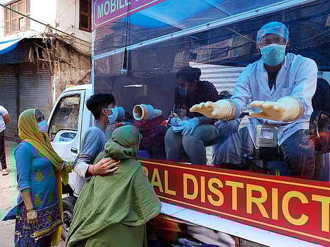 A medical technician speaks to people visiting a mobile Covid-19 testing van operating during a lockdown imposed due to the coronavirus in New Delhi, India, on Monday, April 20, 2020.