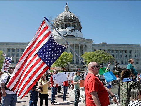 People gather outside the Missouri Capitol to protest stay-at-home orders put into place due to the COVID-19 outbreak Tuesday, April 21, 2020, in Jefferson City. Several hundred gathered to protest the restrictions and urge the reopening of businesses closed in an effort to slow the spread of the coronavirus.