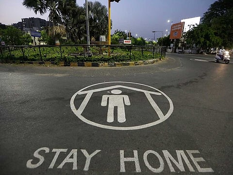 An Indian commuter rides past an awareness message painted on a road during lockdown to control the spread of the new coronavirus in Ahmedabad, India, Thursday, April 23, 2020.