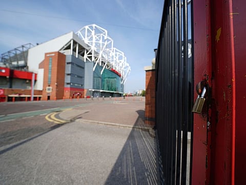 A padlocked gate stands near the closed Manchester United stadium, Old Trafford, in Manchester.