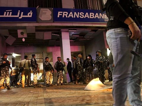 Lebanese security forces inspect the entrance of a Fransabank branch in Lebanon's southern city of Sidon on April 25, after unknown assailants targeted the bank entrance with an explosive device.