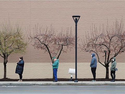 People line up at a safe social distance outside the grocery store amid the COVID-19 outbreak in Medford, Massachusetts.