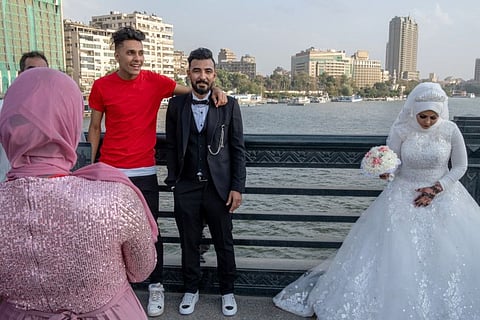 Khalid Hamdan, center, and Faiza Qadri on Qasr Al Nil, a bridge over the Nile often used for wedding photos, in Cairo on April 23. Couples across the Middle East have been undeterred by the coronavirus and are pressing ahead with scaled-back weddings but the local authorities aren’t always thrilled.