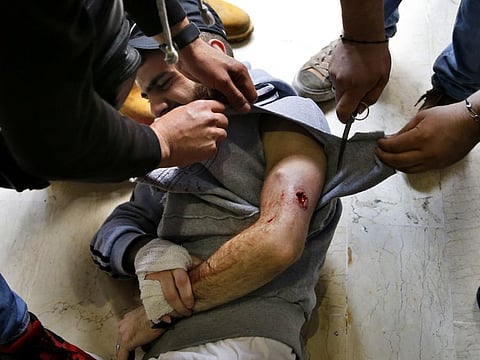 Anti-government protesters help their friend who was wounded by a rubber bullet during clashes with Lebanese army soldiers, in the northern city of Tripoli, Lebanon, Tuesday, April 28, 2020. Hundreds of angry Lebanese took part Tuesday in the funeral of a young man killed in riots overnight in Tripoli that were triggered by the crash of Lebanon's national currency that sent food prices soaring. (AP Photo/Bilal Hussein)
