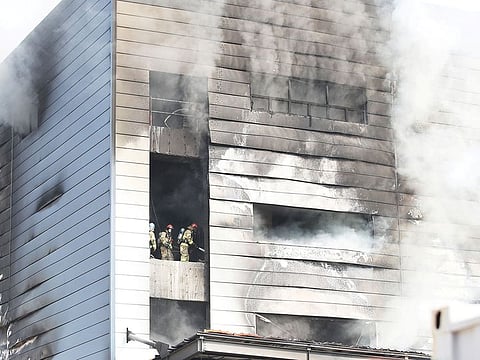 Firefighters try to put out fire as smoke rises from a warehouse which is currently under construction, after it caught fire, in Icheon, South Korea, April 29, 2020.