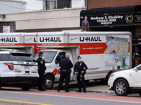 New York City police officers stand by at the Andrew T. Cleckley Funeral Home in the Brooklyn borough of New York, Wednesday, April 29, 2020. Police responded to a report of human bodies in vehicles, which they determined were connected to the nearby funeral home.