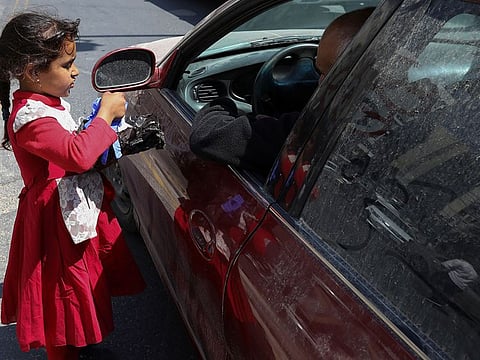 A girl sells protective face masks and gloves at the main market in downtown after the government eased the restrictions on movement aimed at containing the spread of the coronavirus disease (COVID-19), in Amman, Jordan