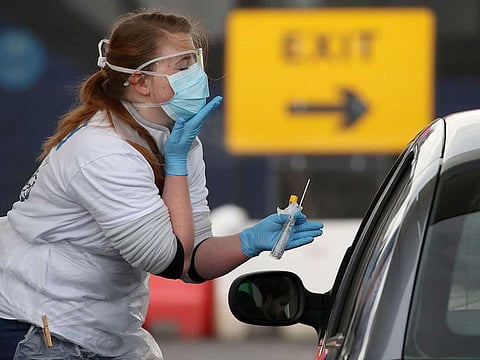 A medical worker tests a key worker for the novel coronavirus Covid-19 at a drive-in testing centre at Glasgow Airport on April 29, 2020, as the UK continues in lockdown to help curb the spread of the coronavirus.