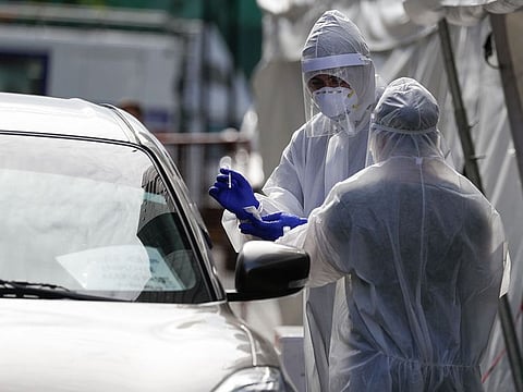 Health workers in protective suits conduct a COVID-19 drive through testing during a continuing enhanced community quarantine to prevent the spread of the new coronavirus in Taguig, Metro Manila, Philippines.