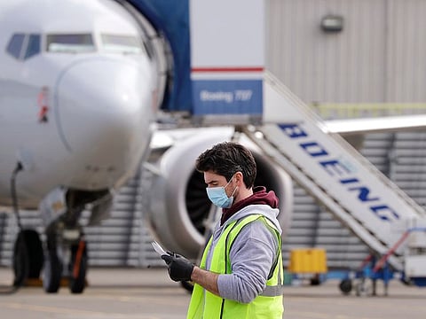 A worker walks past a Boeing 737 MAX jet at a Boeing airplane manufacturing plant Wednesday, April 29, 2020, in Renton, Washington.