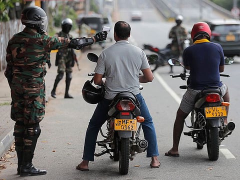 A Sri Lankan army soldier checks the body temperature of a motorcyclist during a curfew imposed to stop the spread of the coronavirus in Colombo, Sri Lanka.