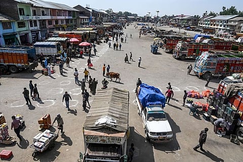 Vendors and buyers trade for fruits and vegetables at a wholesale market on the International Labour Day in Srinagar on May 1, 2020.