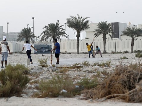 People play cricket on a patch of wasteland in Doha. Most of the new cases are among migrant workers.