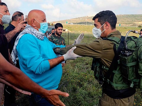 Palestinians from Al Sawiyah village south of Nablus city in the occupied West Bank are prevented by Israeli soldiers from accessing their lands on May 2, 2020, where colonists from the nearby Rahalim colony established mobile housing and cut dozens of olive trees.