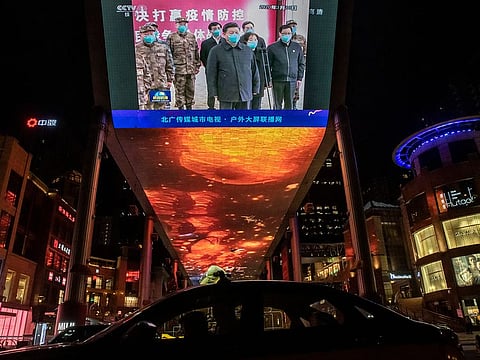 Chinese President Xi Jinping appears on a video screen with army officers and other officials, Beijing, March 19, 2020.
