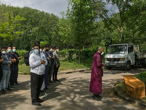 Mourners pray before of an 87-year-old Muslim man originally from Algeria who died of COVID-19, in Thiais, France, April 24. The coronavirus has touched almost every country on earth, but its impact has seemed capricious.