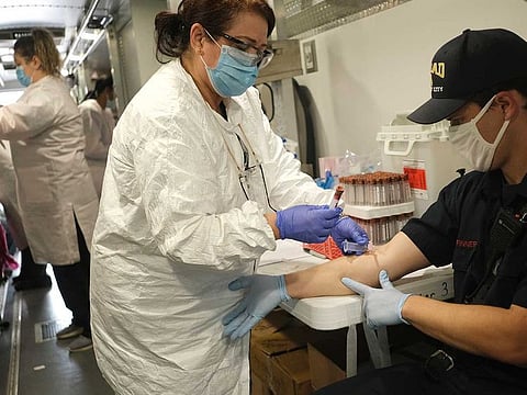 Jersey City firefighter Matt Finnerty, right, has blood drawn to test for coronavirus antibodies at a testing site in Jersey City.