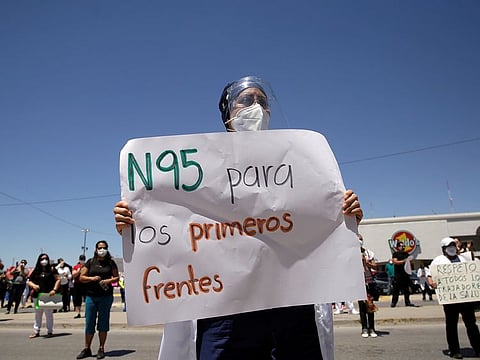 A doctor from the Mexican Institute of Social Security (IMSS) holds a placard during a protest after the death of a colleague, due to what they say is the lack of equipment to treat patients with the coronavirus disease (COVID-19), in Ciudad Juarez, Mexico, May 4, 2020. The placard reads: "N95 for the first front", referring to the mask.