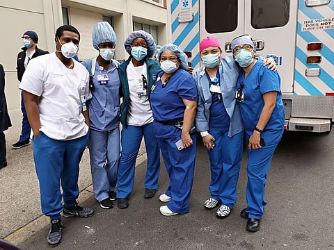 Medical workers from Lenox Hill Hospital come outside while people show gratitude as part of the nightly #ClapBecauseWeCare during the COVID-19 pandemic on May 5, 2020 in New York City.