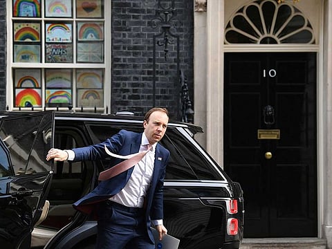 Britain's Health Secretary Matt Hancock arrives in Downing Street, as the UK enters a seventh week of lockdown to help stop the spread of coronavirus, in London, Tuesday May 5, 2020. The rainbow image in the window behind has been adopted nationally as a symbol to thank care workers on the front line to fight the highly contagious COVID-19 coronavirus.