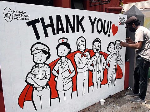 An artist draws graffiti to 'thank coronavirus warriors' on the wall of the Ernakulam General Hospital, in Kochi