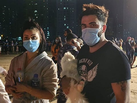 Residents seen wearing face masks after exiting towering inferno in Sharjah