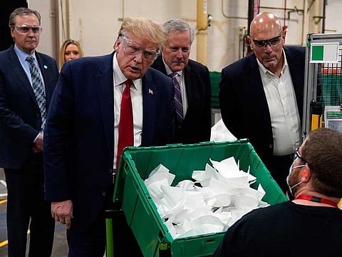 President Donald Trump and Tony Stallings, vice-president of integrated supply chain at Honeywell International Inc., right, listens to a worker during a tour of a Honeywell International plant that manufactures personal protective equipment, May 5, 2020, in Phoenix