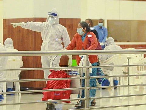 Medics screen passengers after an Air India Express flight brought stranded Indian nationals from Abu Dhabi, UAE, as part of the repatriation exercise ‘Vande Bharat Mission’, at the airport in Kochi, Thursday night, May 7, 2020.