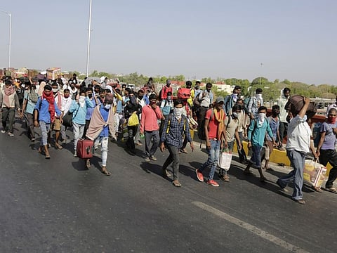 Indian migrant workers walk on a bridge in search of transportation to take them back to their home states, during a nationwide lockdown to curb the spread of new coronavirus, in Ahmedabad.