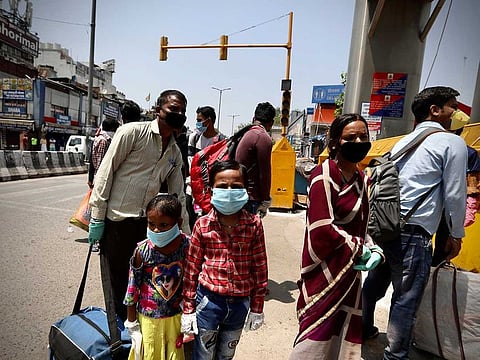 Indians line up to board trains outside New Delhi railway station in New Delhi, India, Tuesday, May 12, 2020. India is reopening some of its colossal rail network as the country looks at easing its nearly seven-week strict lockdown amid an increase in coronavirus infections.
