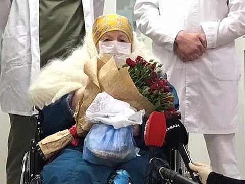 Pelageya Poyarkova, 100, wearing a protective mask poses for a picture as she leaves the Brain Centre in Moscow.