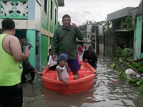 Residents ride a boat along a flooded village as typhoon Vongfong passes by Sorsogon province, northeastern Philippines on Friday May 15, 2020.