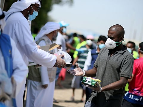 Dr. Hisham Al Zahrani, Deputy Director of Dar Al Ber Society, and Sakhr Al Khalili, Manager-Staff Accommodation, Assets & Property Management - JAFZA, along with Dar Al Ber Society staff distribute 12,000 food meals  and 40,000 Tea Lattes to blue collar workers at their camp in Jebel Ali on 14th May