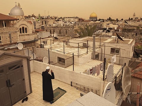 A man prays on a rooftop during Ramadan afternoon prayers in occupied Jerusalem. The coronavirus pandemic has transformed how Muslims in Israel and the Palestinian Territories are experiencing Ramadan.