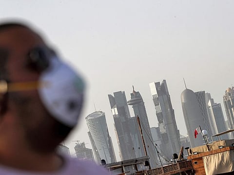In this file photo taken on March 16 , a man in a mask walks along the Doha corniche.