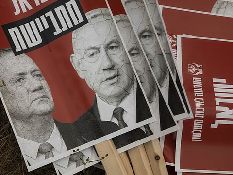 Signs depicting Israeli Prime Minister Benjamin Netanyahu and Blue and White party leader Benny Gantz, are seen during a demonstration outside the Knesset, Israel's parliament in occupied Jerusalem on May 14.