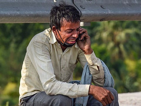 Migrant worker cries on the side of a road in India