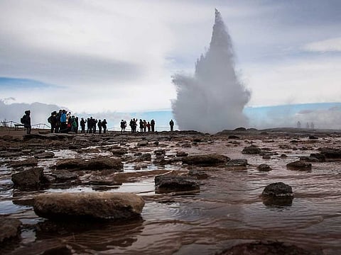 Visitors watch the Strokkur geyser, the most visited geyser in Iceland and a common stop for tourists along the famed Golden Circle in Haukadalsvegur, on April 27, 2016.