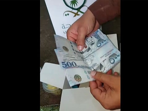 A video emerged showing a man emptying out a Ministry of Health-labeled bag and unpacking a box where he pretends to find SR1,500 in addition to flowers, hand sanitisers and chocolate