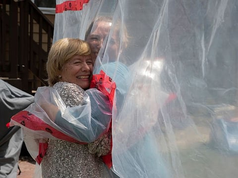 Carolyn Ellis (R) hugs her mother Susan Watts using the "Hug Glove" that Carolyn and her husband Andrew Ellis created as a Mother's Day gift in Guelph, Ontario, Canada, May 16, 2020.