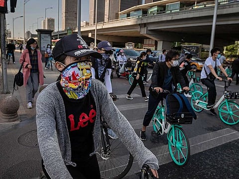 People wearing face masks commute during morning rush hour in Beijing on May 19, 2020.
