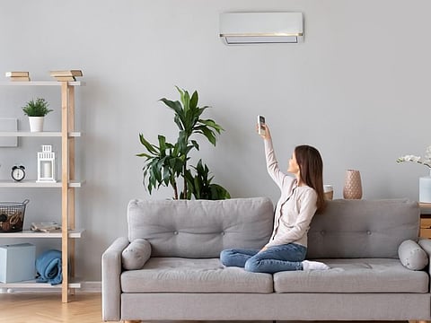 Picture for illustrative purposes: A woman switches on the A/C in her apartment
