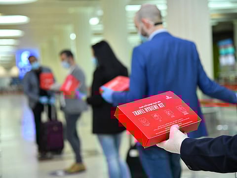 Passengers boarding an Emirates flight with the free hygiene kits given to them
