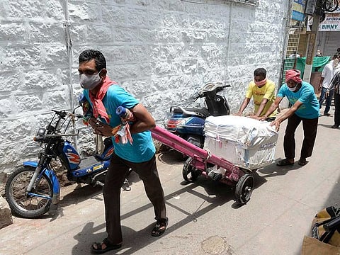 Labourers push a cart in a market after the government eased a nationwide lockdown imposed as a preventive measure against the COVID-19 coronavirus, in Secunderabad the twin city of Hyderabad on May 19, 2020.